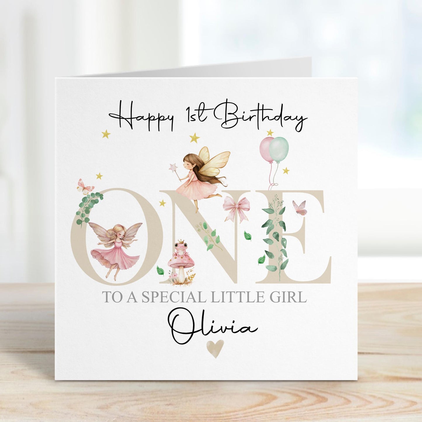 White linen luxury fairy 1st birthday card featuring beautiful little fairies & a pink toadstool & frog prince & the number one in neutral beige & the wording Happy 1st birthday to our special daughter, granddaughter, niece, special little girl, can be adapted to any relation. Personalised with childs name.
