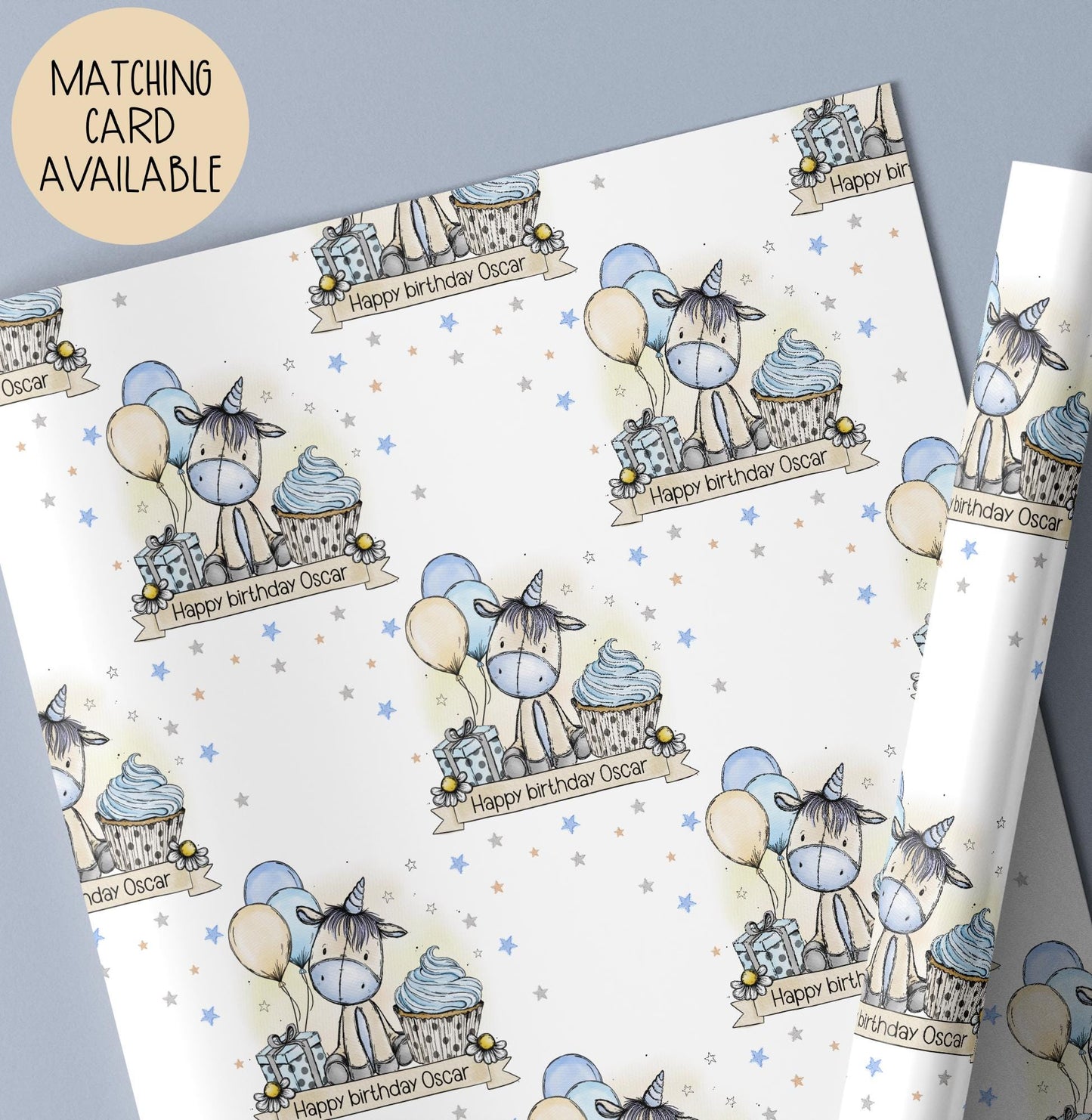 Personalised Unicorn gift wrap featuring hand drawn exclusive artwork of a cute Unicorn with a blue nose & blue & beige balloons & a blue cupcake & the wording Happy Birthday, personalised with a name.