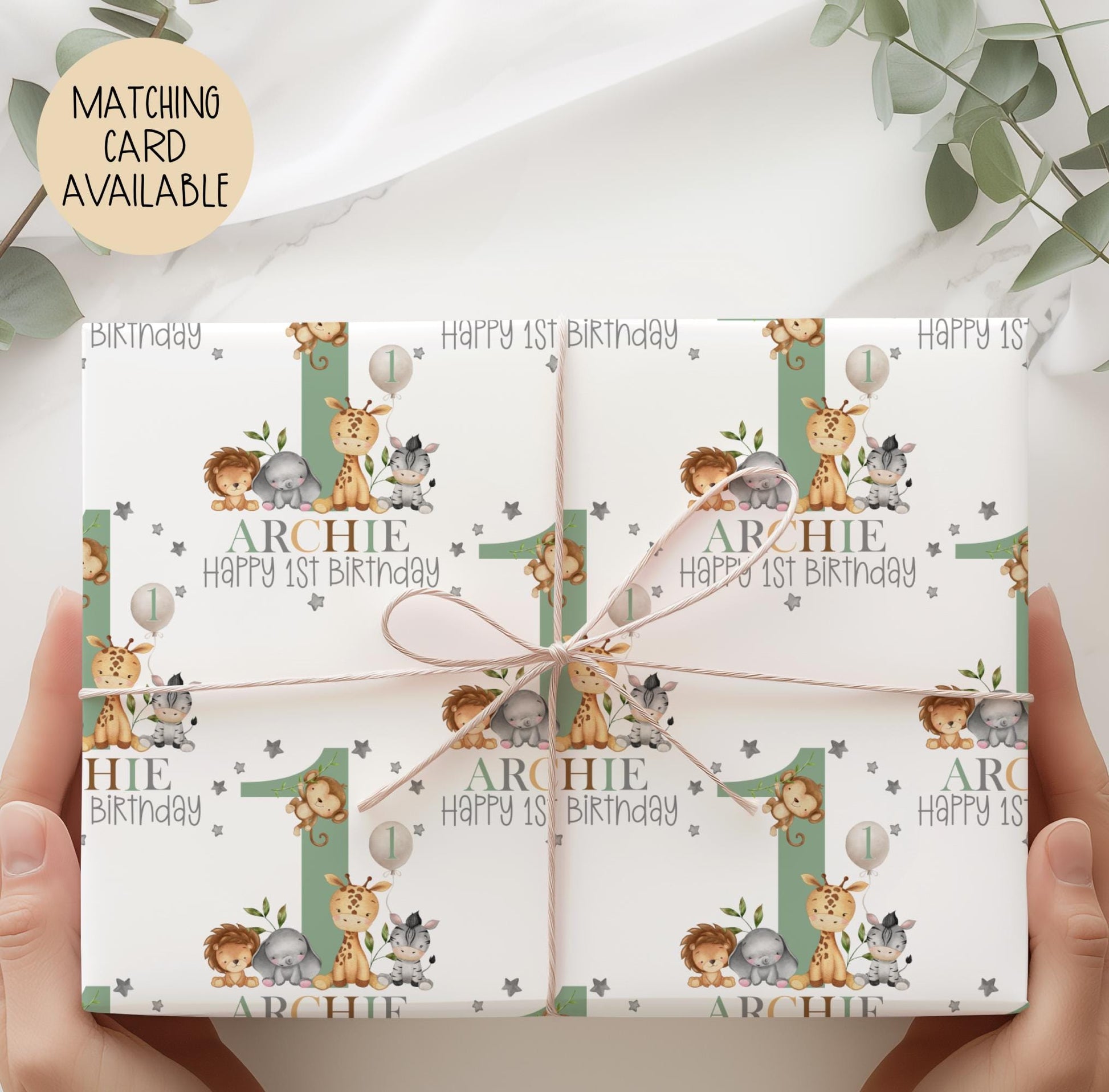 Personalised gift wrap for a 1st birthday featuring a large sage green number '1' surrounded by cute safari animals & grey stars. The design includes the text ' Happy 1st Birthday' Personalised with a name in multi-coloured text.