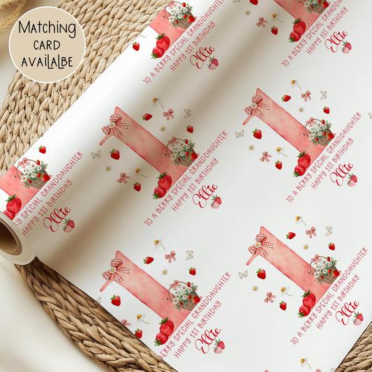 Personalised gift wrap for a 1st birthday featuring a large red watercolor number &#39;1&#39; adorned with strawberries, gingham bows, and flowers. The design includes the text &#39;To a berry special granddaughterDaughter/any relation Happy 1st Birthday&#39; Personalised with a name.