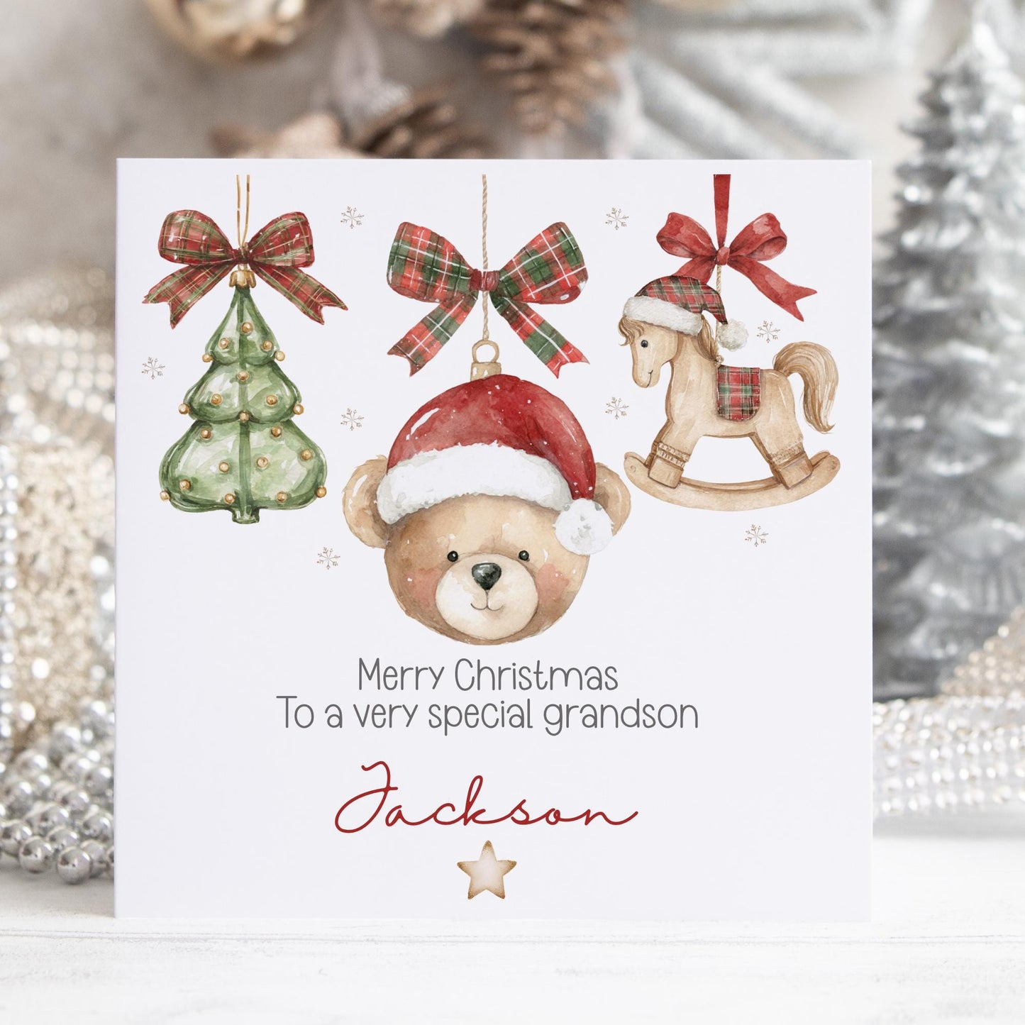 Personalised Christmas card featuring a cute teddy bear wearing a Santa hat, a green Christmas tree, and a rocking horse with red tartan bows. Text reads “Merry Christmas to a very special grandson/son/nephew/any relation.” Personalised with a name. Perfect festive card for any special boy&#39;s Christmas 2025.