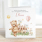Square personalised first birthday greeting card featuring a cute illustrated teddy bear standing in a garden scene with flowers, a wooden fence, sunshine, gifts and a balloon showing the number one. The card includes personalised text for a child’s name and relation, with a soft pastel colour theme.