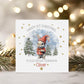 Personalised baby’s 1st Christmas card for Boys & girls featuring a cute bunny in a red hat holding a present, snowy woodland background with fir trees and gold stars. Printed on premium 300gsm card.