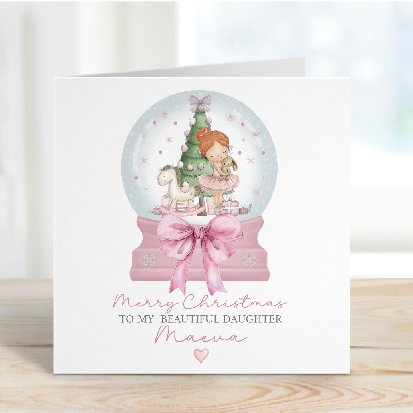 Square personalised Christmas card featuring a ballerina holding a teddy inside a pink snow globe with a Christmas tree, rocking horse, and presents. Text reads “Merry Christmas to our beautiful granddaughter/Daughter/Any relations&quot; Personalised with a name.