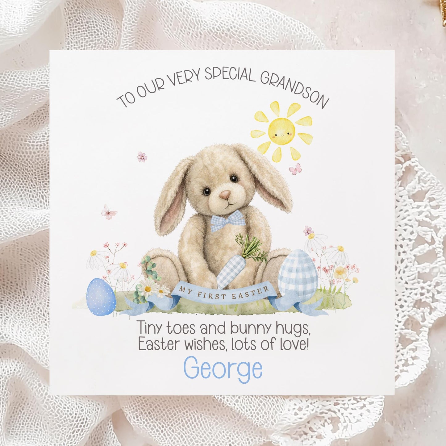 Personalised first Easter card for a grandson featuring a soft illustrated bunny holding a carrot, surrounded by pastel Easter eggs, flowers and a smiling sun, with “My First Easter” banner and space for a personalised name.