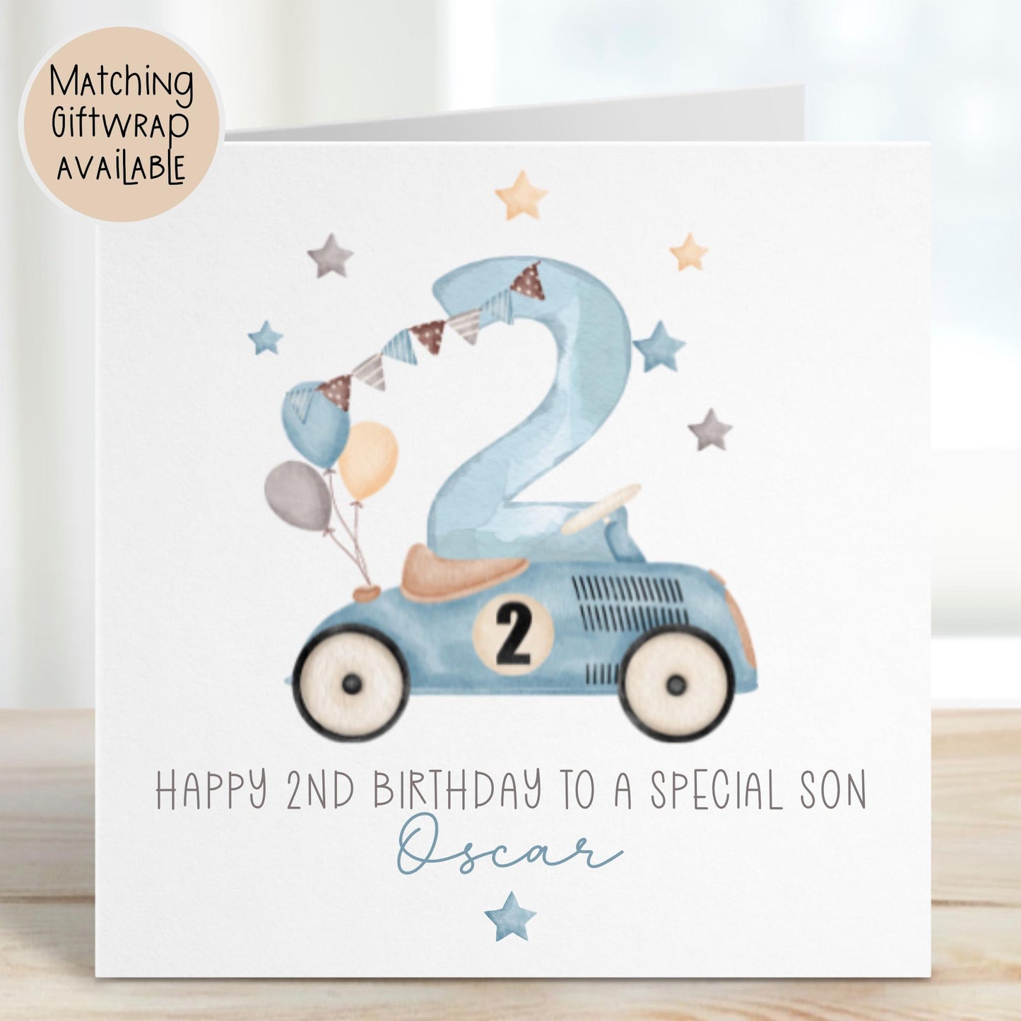 Luxury white linen, lightly textured 1st birthday card featuring a watercolor blue racing car with a number 2  on the side & beige seat & balloons to the back & a watercolor number 2 & a beige, brown & blue bunting & stars & the wording, Happy 1st birthday to a special Grandson/Son/Nephew/wording can be changed to suit. Personalised with the childs name a little star underneath. Card measures 6 x 6 inches.