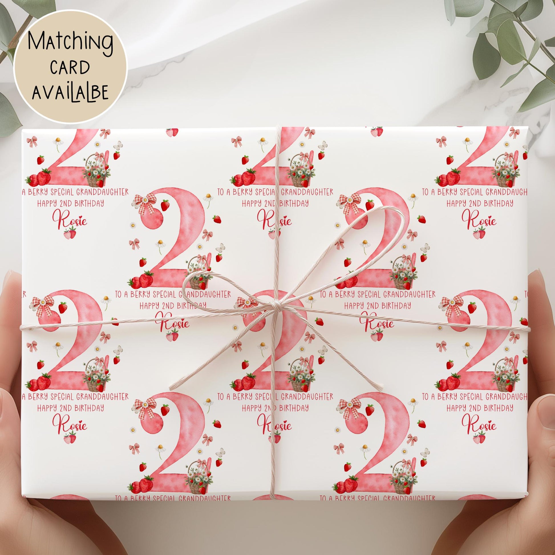 Personalised gift wrap for a 2nd birthday featuring a large red watercolor number &#39;2&#39; adorned with strawberries, gingham bows, and flowers. The design includes the text &#39;To a berry special granddaughterDaughter/any relation Happy 1st Birthday&#39; Personalised with a name.