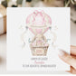 Square personalised Easter greeting card featuring an illustrated bunny sitting in a wicker basket hot air balloon in soft pink pastel tones. The design includes Easter eggs, ribbon details and a banner reading ‘Happy Easter’. The card has space for personalised text for name, year and relation.