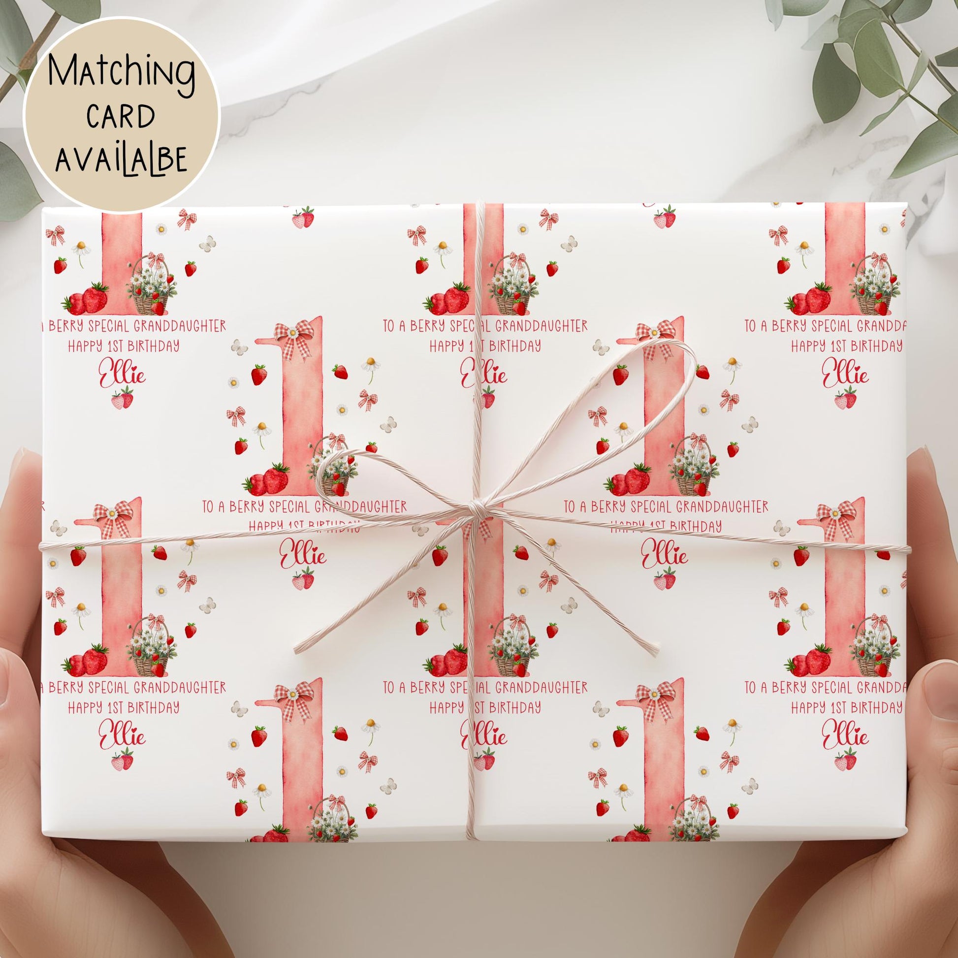 Personalised gift wrap for a 1st birthday featuring a large red watercolor number &#39;1&#39; adorned with strawberries, gingham bows, and flowers. The design includes the text &#39;To a berry special granddaughterDaughter/any relation Happy 1st Birthday&#39; Personalised with a name.