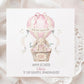 Square personalised Easter greeting card featuring an illustrated bunny sitting in a wicker basket hot air balloon in soft pink pastel tones. The design includes Easter eggs, ribbon details and a banner reading ‘Happy Easter’. The card has space for personalised text for name, year and relation.