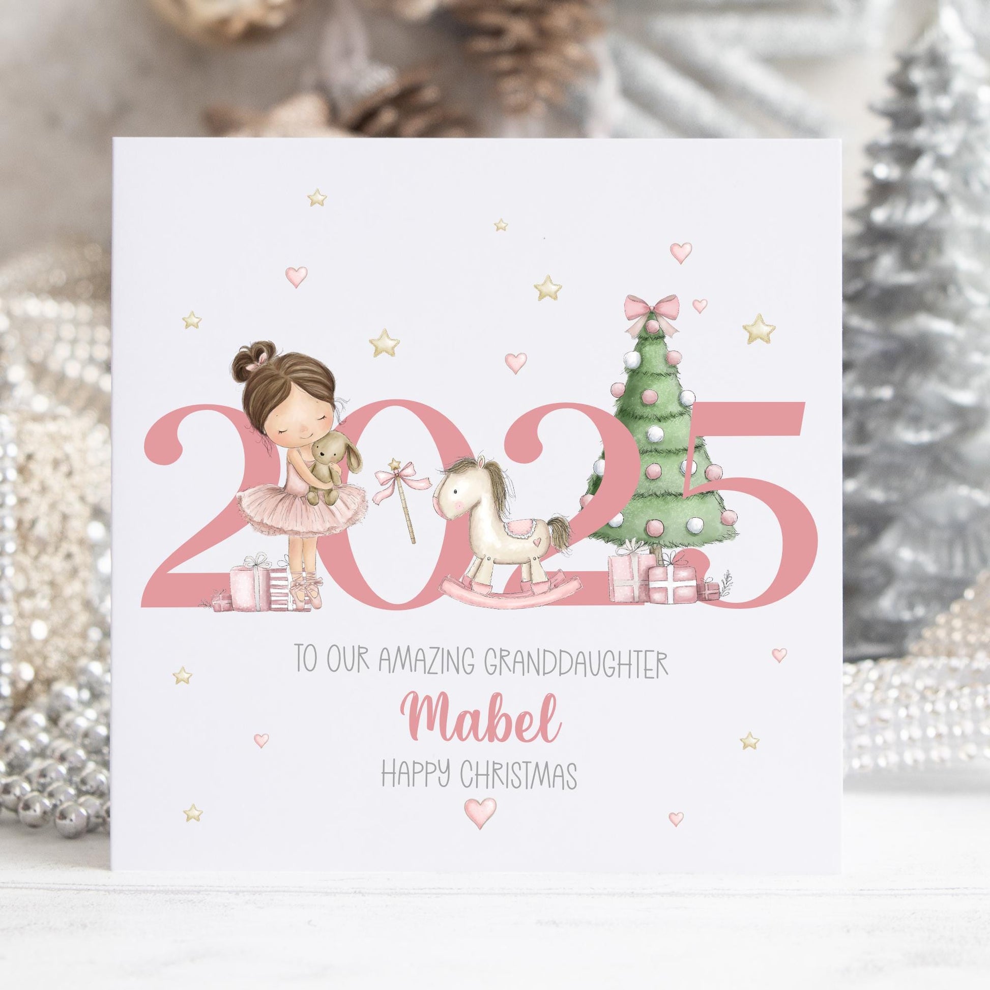 Personalised Christmas card featuring a sweet pink ballerina girl with a teddy bear, rocking horse, and Christmas tree beside the year 2025 in pink. Ideal for a daughter, granddaughter, niece, or any special little girl.