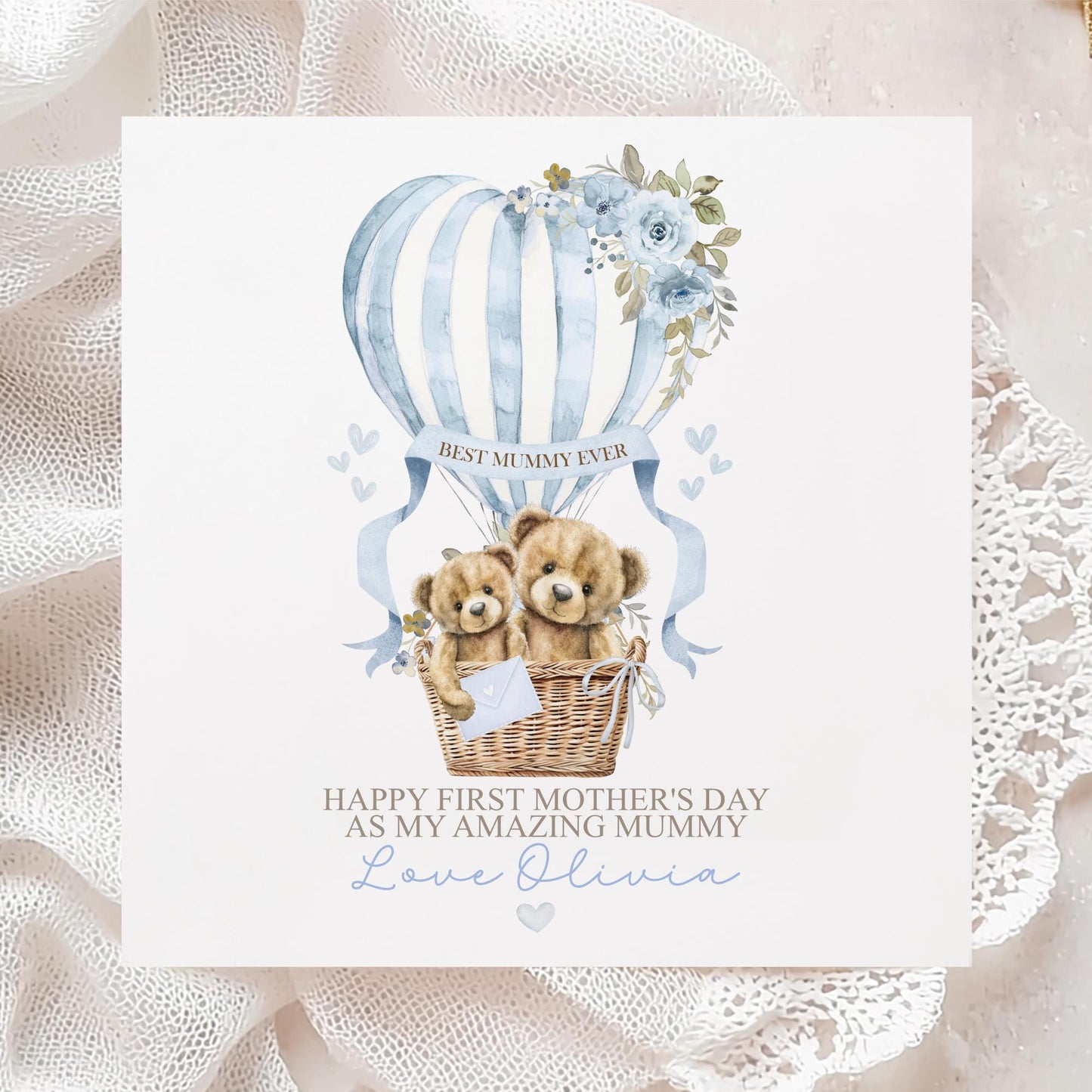 Personalised first Mother’s Day card for new mum, featuring two teddy bears in a wicker basket inside a blue hot air balloon with soft florals and hearts and the wording 'Happy 1st mothers day as my amazing mummy' Personalised with a name.