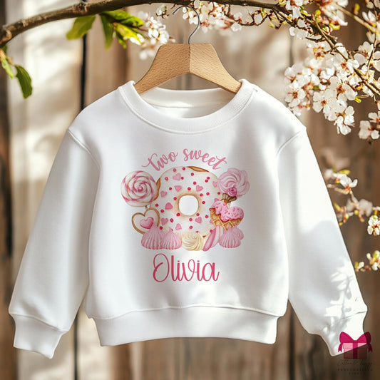 White cotton sweatshirt with the wording &#39;Two sweet&#39;  featuring a doughnut with heart shaped sprinkles & pink candies, personalised with childs name