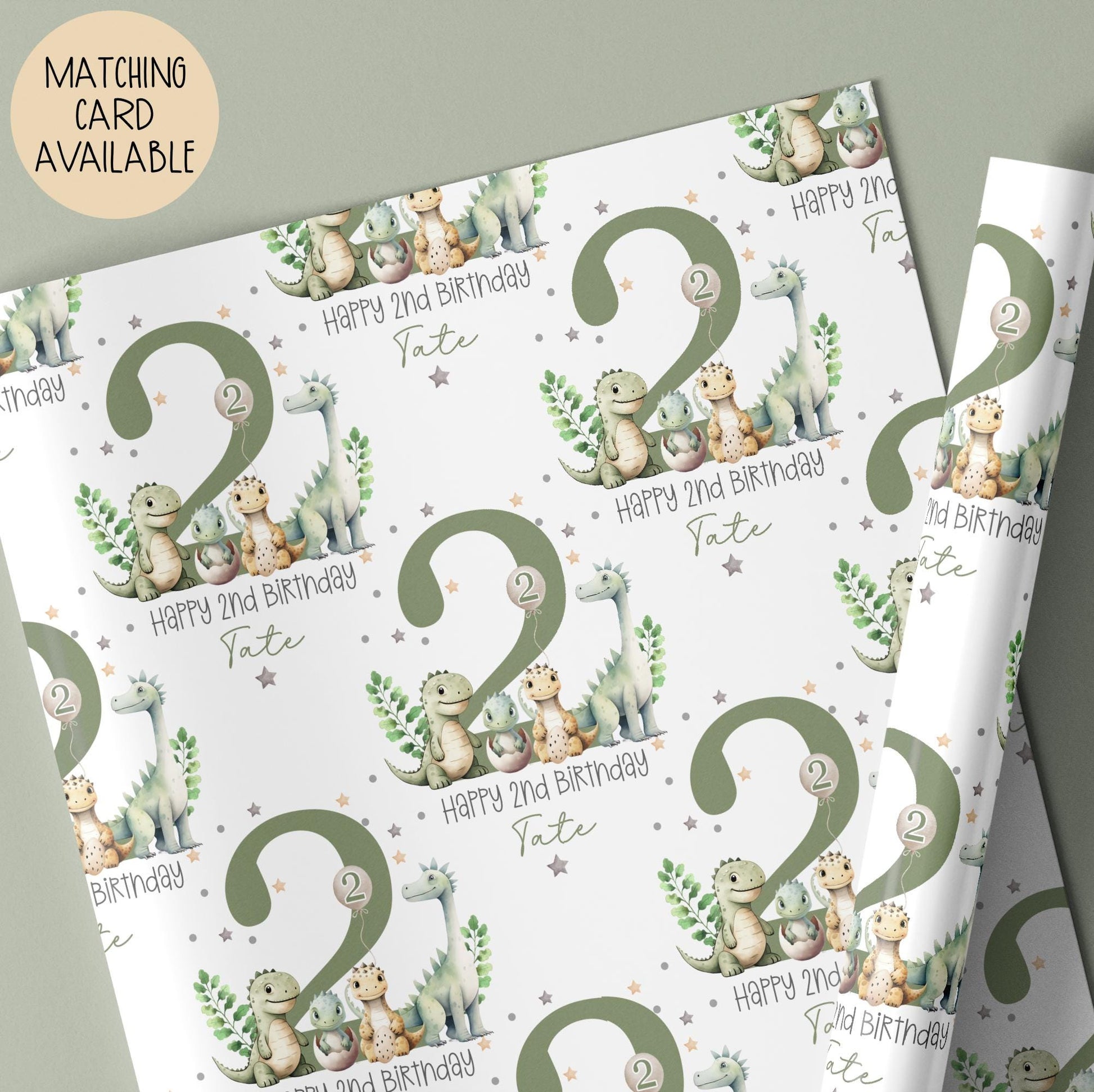 Personalised gift wrap for a 2nd birthday featuring a large sage green number '2' surrounded by cute dinosaurs & stars. The design includes the text ' Happy 2nd Birthday' Personalised with a name.