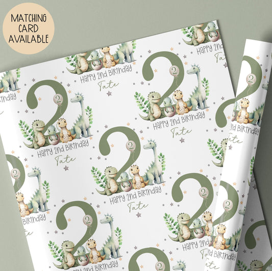 Personalised gift wrap for a 2nd birthday featuring a large sage green number '2' surrounded by cute dinosaurs & stars. The design includes the text ' Happy 2nd Birthday' Personalised with a name.