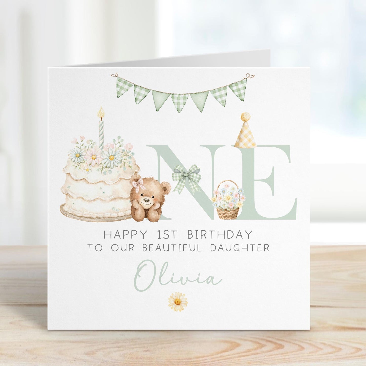 Square personalised first birthday greeting card featuring soft pastel illustrations including a teddy bear, birthday cake with candle, bunting, flowers and a gift basket. The design displays the word ‘ONE’ with decorative details and space for personalised name and relation text.