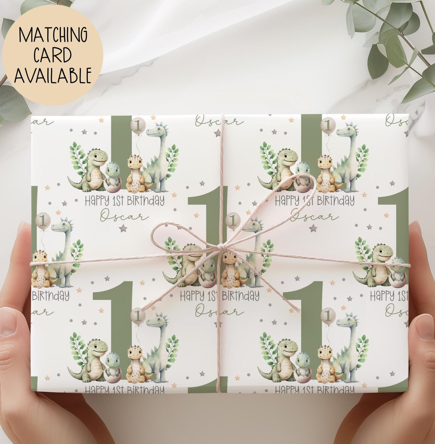 Personalised gift wrap for a 1st birthday featuring a large sage green number '1' surrounded by cute dinosaurs & stars. The design includes the text ' Happy 1st Birthday' Personalised with a name.