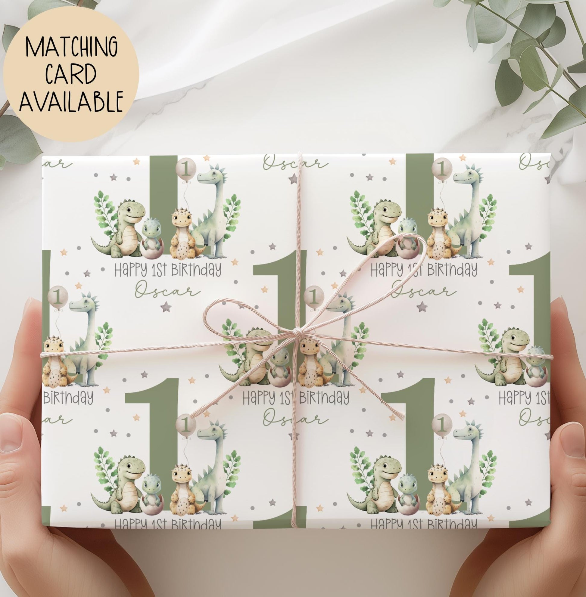 Personalised gift wrap for a 1st birthday featuring a large sage green number '1' surrounded by cute dinosaurs & stars. The design includes the text ' Happy 1st Birthday' Personalised with a name.