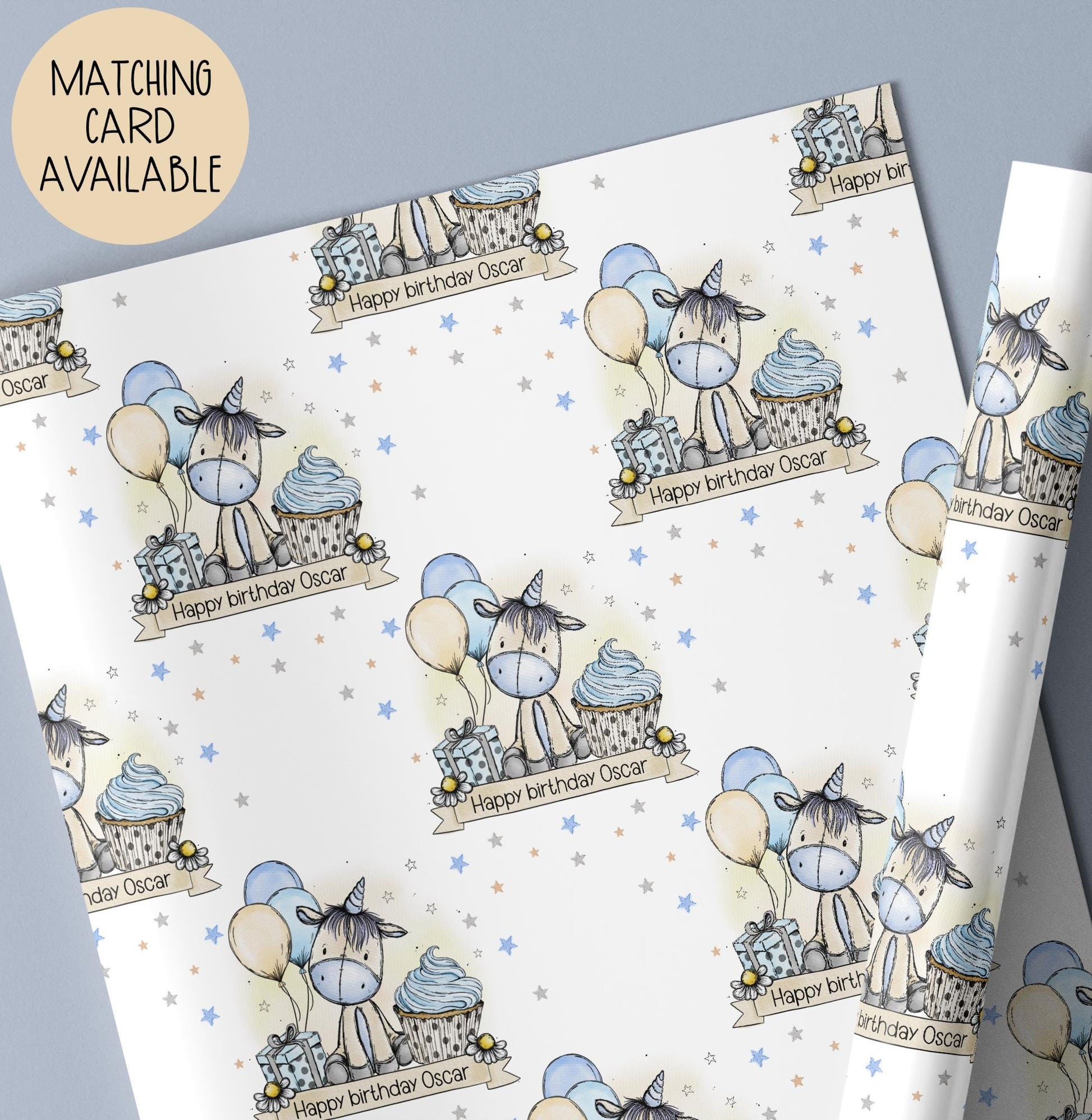 Personalised Unicorn gift wrap featuring hand drawn exclusive artwork of a cute Unicorn with a blue nose & blue & beige balloons & a blue cupcake & the wording Happy Birthday, personalised with a name.