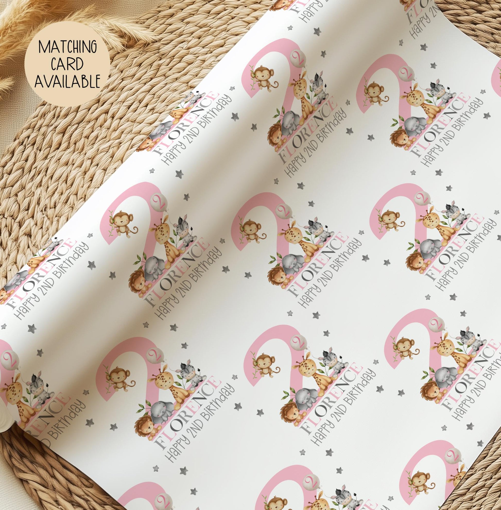 Personalised gift wrap for a 2nd birthday featuring a large pink number &#39;2&#39; surrounded by cute safari animals & grey stars. The design includes the text &#39; Happy 2nd Birthday&#39; Personalised with a name in multi-coloured text.