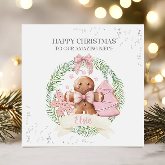 Square white 300gsm Christmas card featuring a Christmas green wreath with a pink Christmas tree & gingerbread wearing a pink bow & the wording &#39;Happy Christmas to or amazing Granddaughter/Niece/Daughter/any relation.