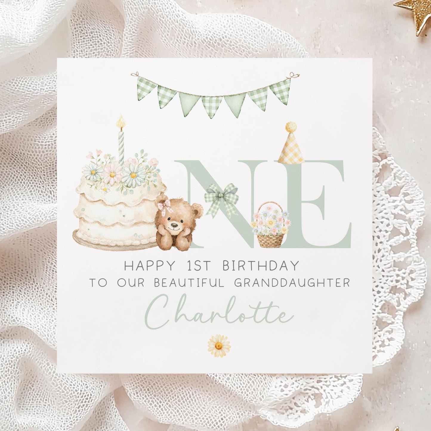 Square personalised first birthday greeting card featuring soft pastel illustrations including a teddy bear, birthday cake with candle, bunting, flowers and a gift basket. The design displays the word ‘ONE’ with decorative details and space for personalised name and relation text.