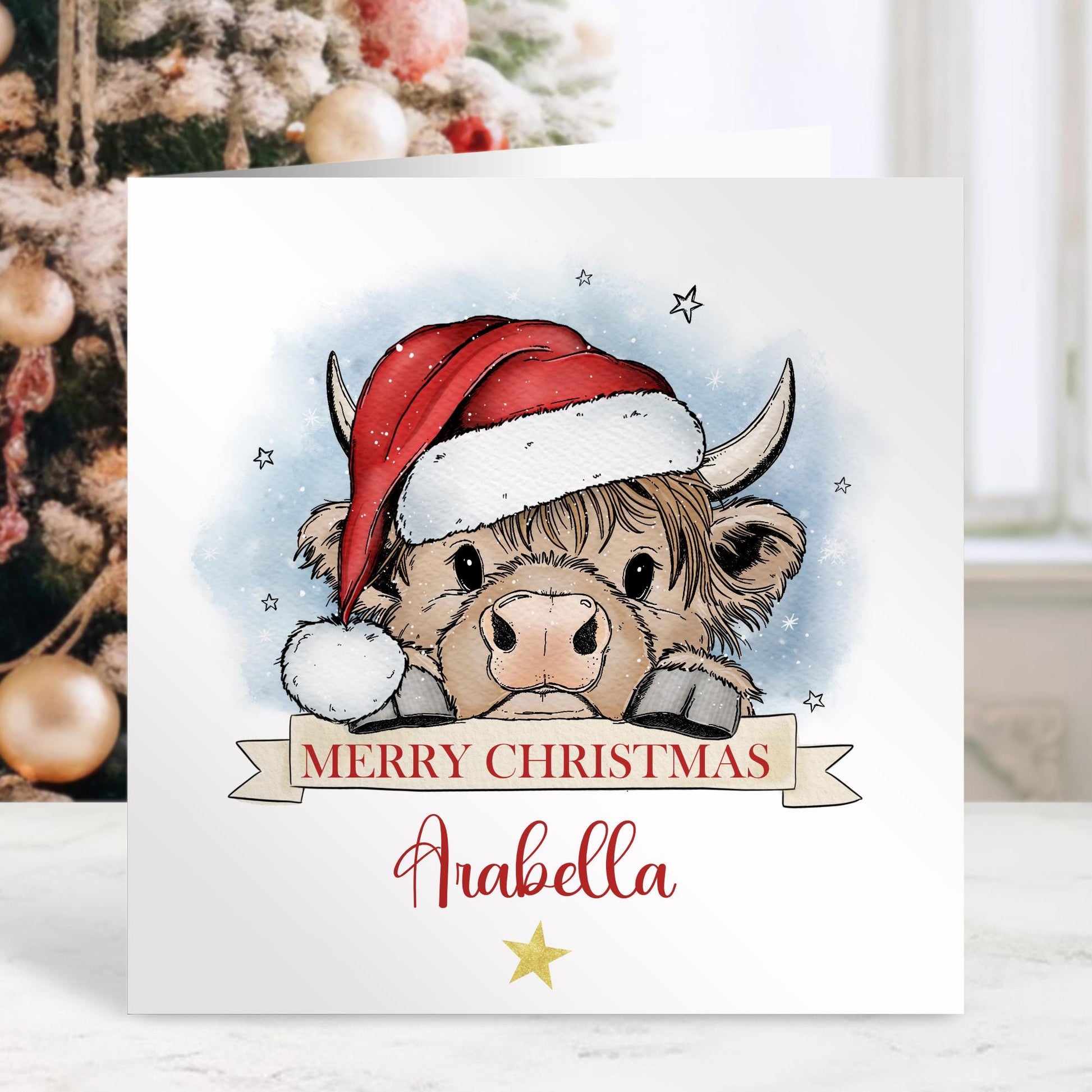 Personalised Christmas card featuring a cute Highland cow wearing a Santa hat with a “Merry Christmas” banner and space for a name. A festive design perfect for all ages.